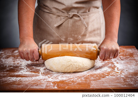 Housewife flattening a dough 100012404