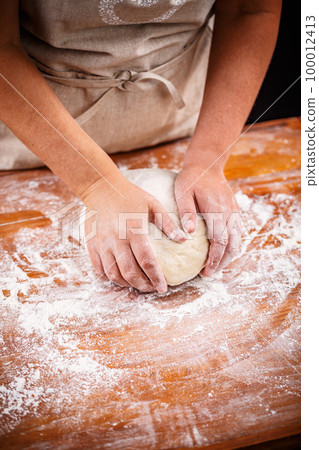 Female hands making bread dough 100012413