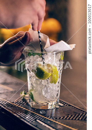 Mixologist barman making mixed alcoholic cocktail Mixologist barman making mixed alcoholic cocktail 100013017