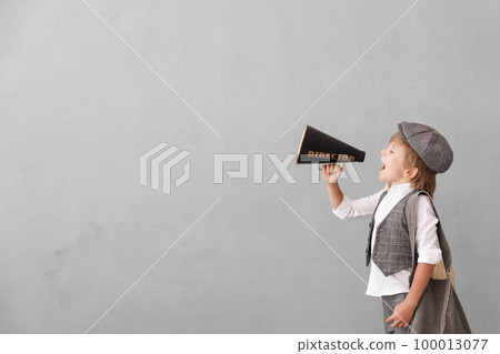 Newsboy shouting against grunge wall background. Boy selling newspaper Newsboy shouting against grunge wall background. Boy selling newspaper 100013077