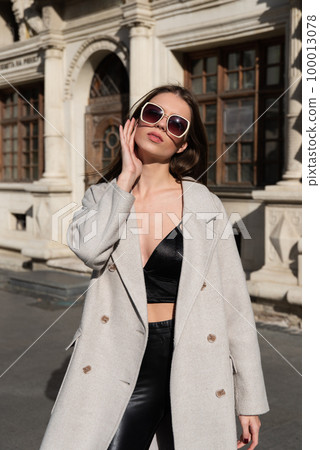 Street style, autumn, spring fashion concept: fashionable woman wearing luxury beige coat, a top with razors and sunglasses Street style, autumn, spring fashion concept: fashionable woman wearing luxury beige coat, a top with razors and sunglasses 100013078