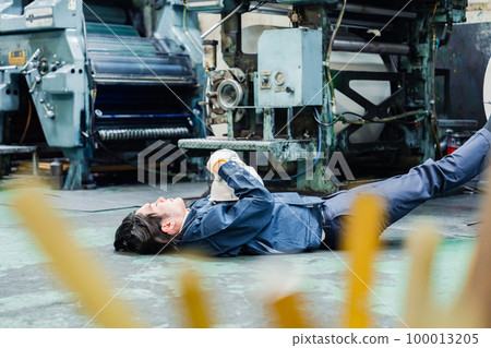 A worker lying down in a factory A worker lying down in a factory 100013205
