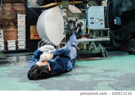 A worker lying down in a factory A worker lying down in a factory 100013210