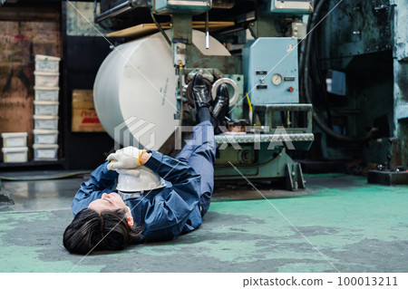 A worker lying down in a factory A worker lying down in a factory 100013211
