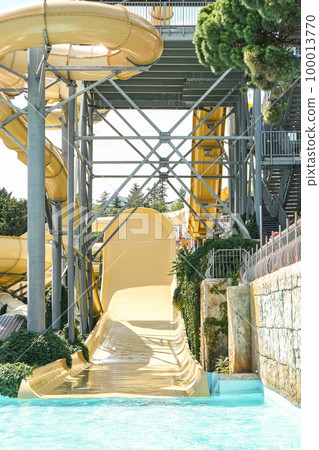 Water park slide pipes and railing on metal frame. Fun attractions for kids and adults in water park at summer resort Water park slide pipes and railing on metal frame. Fun attractions for kids and adults in water park at summer resort 100013770