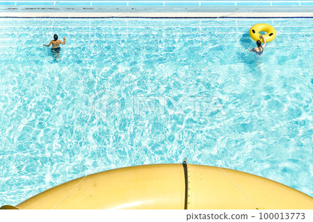 People relax on inflatable rubber rings in swimming pool with clear blue water. Fun activities in water park at summer resort upper view People relax on inflatable rubber rings in swimming pool with clear blue water. Fun activities in water park at summer resort upper view 100013773