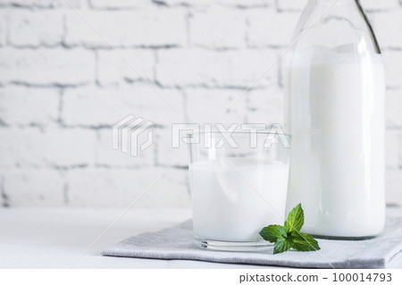 Organic probiotic milk kefir drink or yogurt in glass containers,on the white grey background. Gut health. Probiotic cold fermented dairy drink. Trendy food and drink. Copy space 100014793