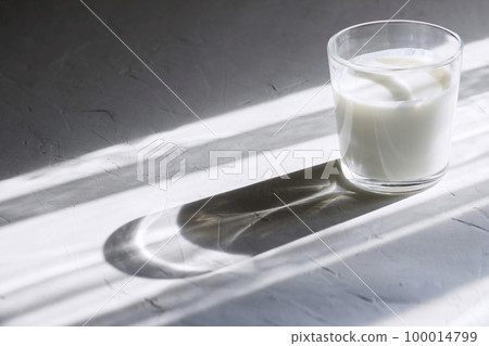 Organic probiotic milk kefir drink or yogurt in glass containers,on the white grey background. Gut health. Probiotic cold fermented dairy drink. Trendy food and drink. Shadow trend Copy space 100014799
