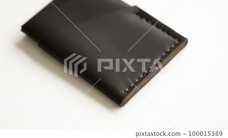 Brown empty men's business handmade genuine leather card holder with isolated on white background. Selective focus, copy space, close up. Brown empty men's business handmade genuine leather card holder with isolated on white background. Selective focus, copy space, close up. 100015389