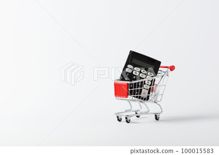 Shopping cart trolley and calculator on white background with copy space. Savings, consumerism concept Shopping cart trolley and calculator on white background with copy space. Savings, consumerism concept 100015583