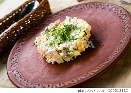salad with peas and mayonnaise, served in a cylinder on a clay plate 100018182