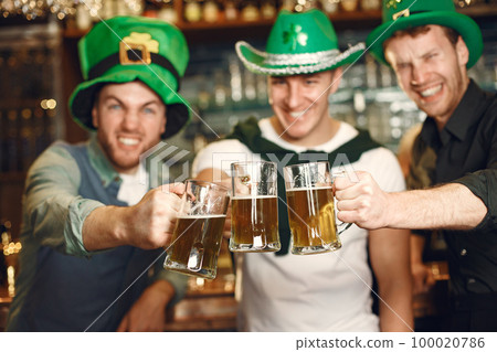 Men celebrate St. Patrick's Day at bar with a mug of beer 100020786