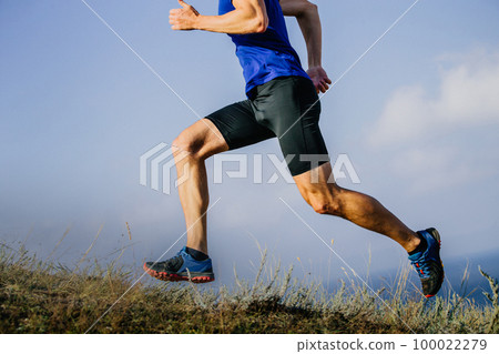 muscular legs runner run trail on dry grass 100022279