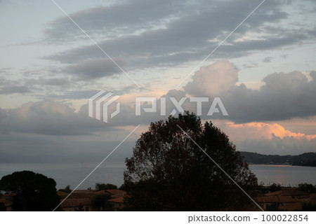 Cloudy Weather Before Rain From Corfu Island Overlooking Mountains Of Balkan Peninsula Of Greece, Moraitika, Corfu. In Foreground Are Hotel Buildings, Trees, Bungalow And Water Slide.  100022854
