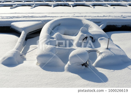 boat with motor covered with snow in winter at the boat parking 100026619