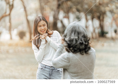 Portrait of an adult daughter with her elderly mother and take a photo and happy moment 100027569