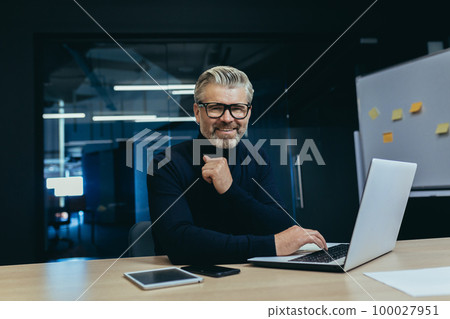 Portrait of senior mature adult businessman inside office, gray haired male investor at workplace smiling and looking at camera. Portrait of senior mature adult businessman inside office, gray haired male investor at workplace smiling and looking at camera. 100027951