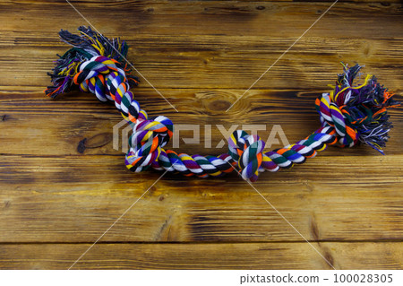 Colorful rope toy for dog on wooden background 100028305