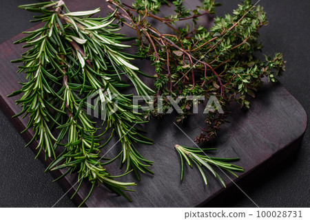 Sprigs of fresh green rosemary on a wooden cutting board 100028731