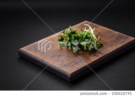 Fresh sprouts or sunflower microgreens on wooden cutting board 100028745