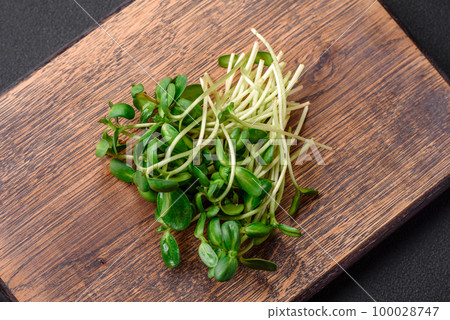 Fresh sprouts or sunflower microgreens on wooden cutting board Fresh sprouts or sunflower microgreens on wooden cutting board 100028747