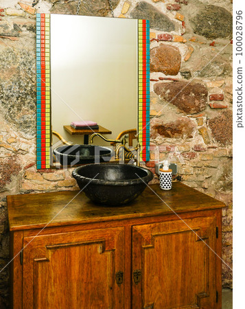 Vintage style bathroom interior with black round ceramic sink with brass faucet on top of cabinet Vintage style bathroom interior with black round ceramic sink with brass faucet on top of cabinet 100028796