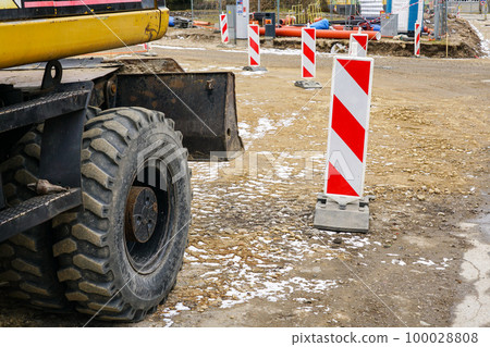 Abstract view of city street reconstruction works, excavator, red and white striped warning signs Abstract view of city street reconstruction works, excavator, red and white striped warning signs 100028808