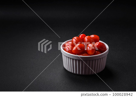Fresh tasty cherry tomatoes in a white ribbed bowl 100028942