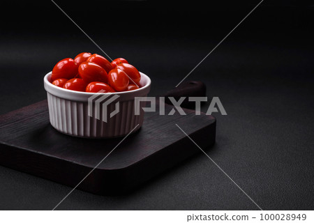 Fresh tasty cherry tomatoes in a white ribbed bowl 100028949
