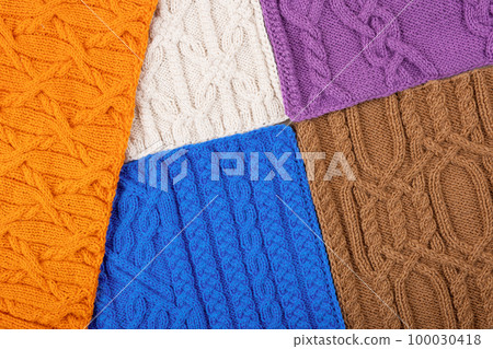 Knitted blue, lilac, brown, orange and beige background. Large knitted fabric with a pattern. Close-up of a knitted blanket. Banner 100030418