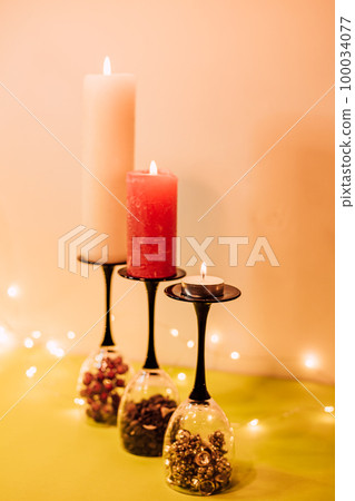 Composition of glasses, candles and decorative elements. New Year's mood Composition of glasses, candles and decorative elements. New Year's mood 100034077