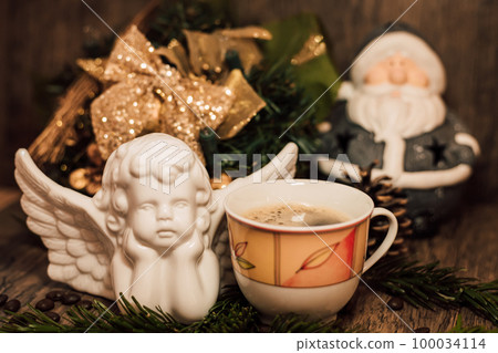 Christmas composition angel, cup of coffee on a dark wooden table 100034114