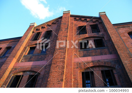 The wall of the Yokohama Red Brick Warehouse illuminated by the setting sun 100034993