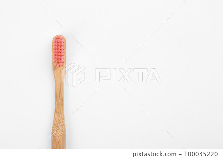 Bamboo toothbrush with pink bristle isolated on white, top view Bamboo toothbrush with pink bristle isolated on white, top view 100035220