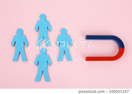 Magnet attracting paper people on pink background, flat lay Magnet attracting paper people on pink background, flat lay 100035287