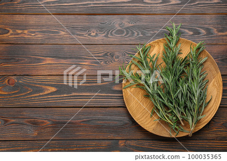 Bunch of fresh rosemary on wooden table, top view. Space for text Bunch of fresh rosemary on wooden table, top view. Space for text 100035365