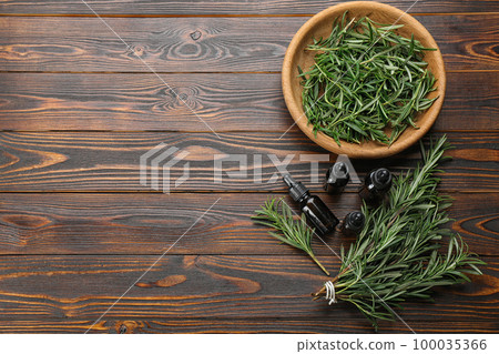 Flat lay composition with fresh rosemary on wooden table. Space for text 100035366