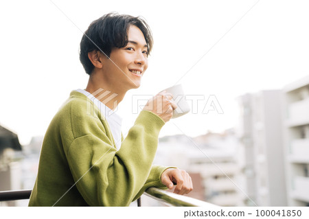 man drinking coffee on the balcony 100041850