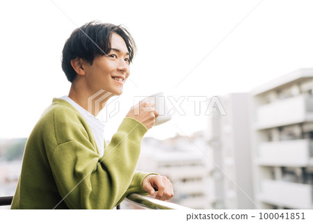 man drinking coffee on the balcony 100041851