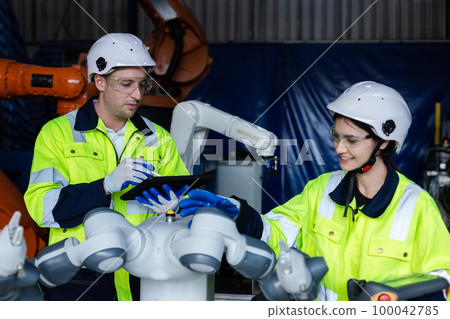 Engineer teamwork using tablet control and checking system robot arm automate. Engineer teamwork using tablet control and checking system robot arm automate. 100042785