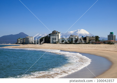 <Tottori Prefecture> Kaike Onsen Town and Snow-capped Mt. Daisen seen from Kaike Beach, February <Tottori Prefecture> Kaike Onsen Town and Snow-capped Mt. Daisen seen from Kaike Beach, February 100042857