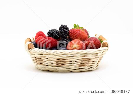 summer berries in a wicker basket on a white background 100048387