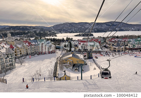 Mont Tremblant village and lake in winter with funiculars in foreground, Quebec, Canada 100048412