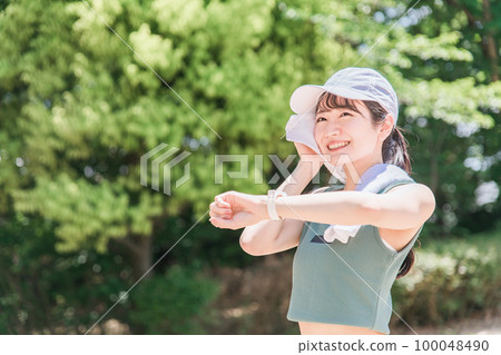 一位女士在公園裡邊看手錶邊鍛煉、訓練和散步(時間、時間、醫療保健) 一位女士在公園裡邊看手錶邊鍛煉、訓練和散步(時間、時間、醫療保健) 100048490
