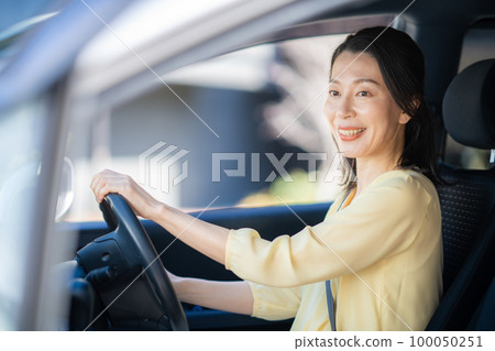 Middle woman driving with a smile 100050251
