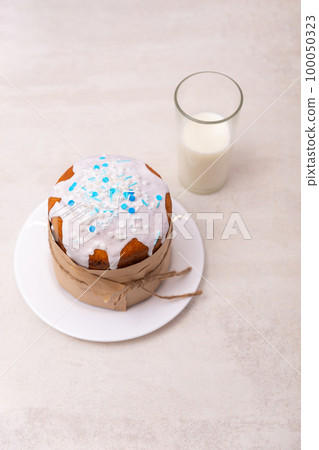 An Easter cake and a glass glass with milk are on the table. 100050323