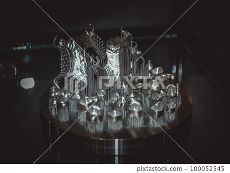 Object printed on metal 3d printer close-up. Object printed in laser sintering machine. Modern 3D printer printing from metal powder. Concept progressive additive DMLS, SLM, SLS Object printed on metal 3d printer close-up. Object printed in laser sintering machine. Modern 3D printer printing from metal powder. Concept progressive additive DMLS, SLM, SLS 100052545