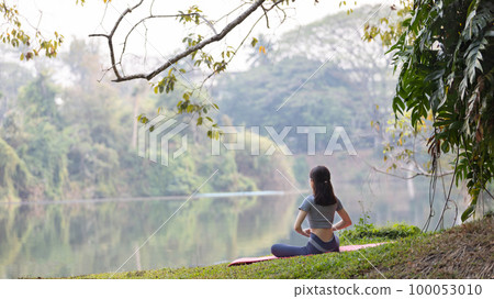Asian woman doing yoga in nature in the forest, Meditation and breathing exercises, Treat ADHD and train your mind to be calm, Healthy exercise, Mindfulness, Homeopathy, Park yoga. 100053010