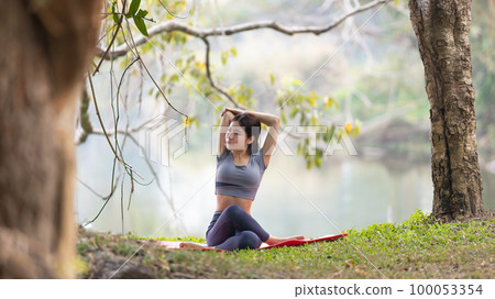 Asian woman doing yoga in nature in the forest, Meditation and breathing exercises, Treat ADHD and train your mind to be calm, Healthy exercise, Mindfulness, Homeopathy, Park yoga. 100053354