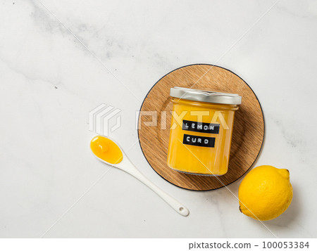 Homemade lemon curd in jar, top view, vertical 100053384